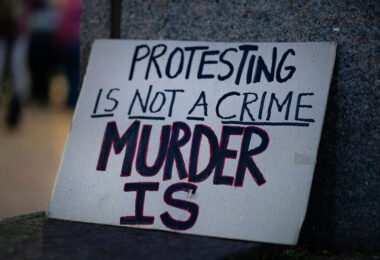 "Protesting is not a crime murder is" protest sign seen in Downtown Minneapolis