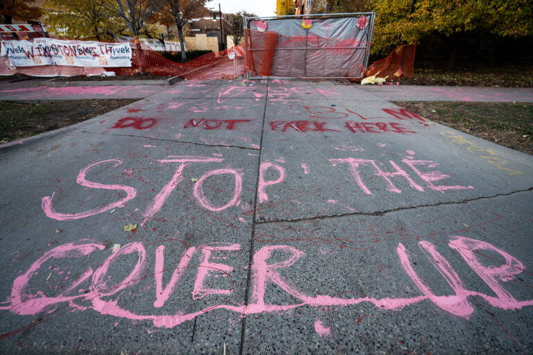 Stop The Cover Up graffiti behind Seven Points Mall 2 Protesters paint "Stop The Cover Up" outside the parking garage where Winston Smith was killed by law enforcement 5 months earlier.