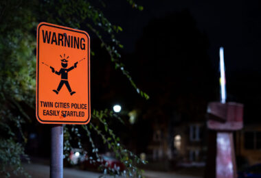 A sign reading "Warning Twin Cities Police Easily Startled" at 39th and Chicago Avenue, George Floyd Square.