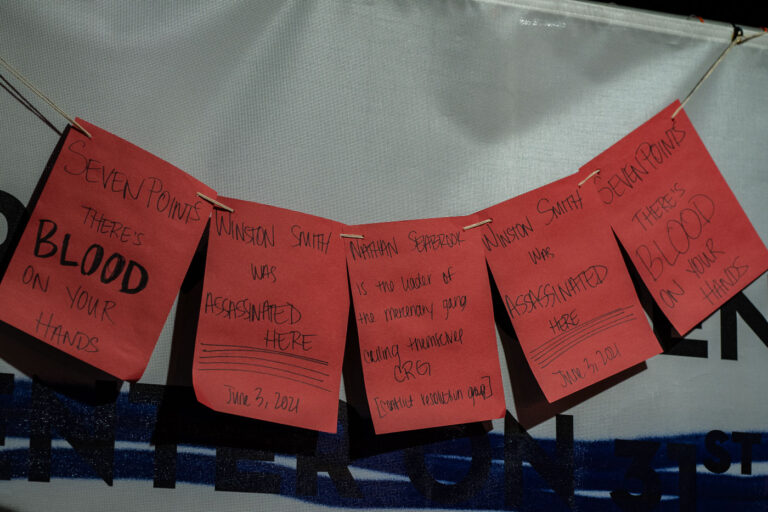 Winston Smith Protest Notes 3 Protest signs hang on fencing around the parking ramp where Winston Smith was killed by law enforcement on June 3, 2021.