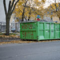 A dumpster with "Winston Smith" written on it. Smith was shot and killed by a federal task force on top of the parking garage across the street.