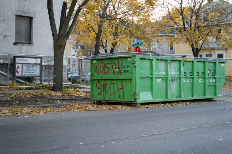 Winston Smith written on a dumpster 1 A dumpster with "Winston Smith" written on it. Smith was shot and killed by a federal task force on top of the parking garage across the street.