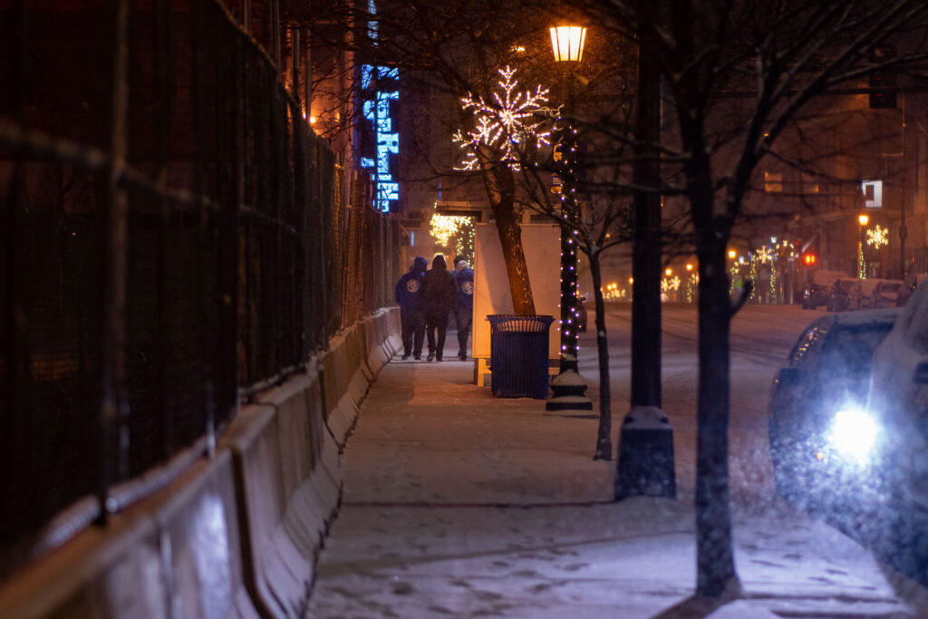 "We push for peace", a nonprofit organization that partners with police to de-escalate situations walks through Uptown Minneapolis on a snowy December evening.