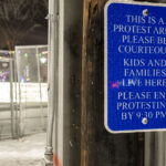 A sign placed outside the Brooklyn Center Police Department asking protests to finish by 9:30pm.