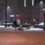 A biker with a burley trailer during heavy snowflal in Uptown Minneapolis.