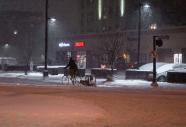 A biker with a burley trailer during heavy snowflal in Uptown Minneapolis.