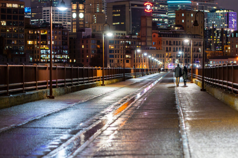 Couple walk the Stone Arch Bridge in December 2021 3 A couple holds hands walking over the Stone Arch Bridge in downtown Minneapolis.