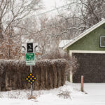 Welcome to Kingfield Neighborhood sign in Minneapolis during a December snowstorm.