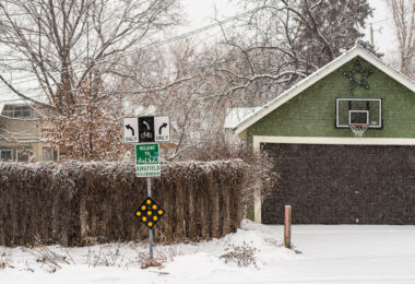 Welcome to Kingfield Neighborhood sign in Minneapolis during a December snowstorm.