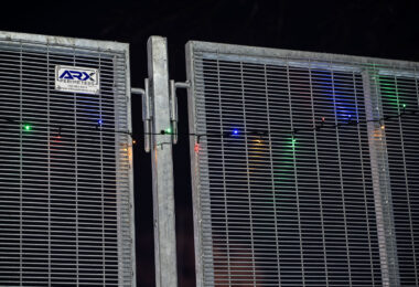 Holiday lights hanging on the ARX Perimeters fencing that surround the Brooklyn Center police station. The fencing surrounds the facility after the shooting death of Daunte Wright in April.
