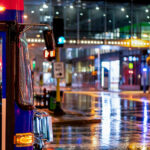 A Metro Transit bus crossing Marquette Ave in downtown Minneapolis on a rainy December night.