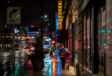 A couple walks down 1st Avenue in downtown Minneapolis during a December rain.