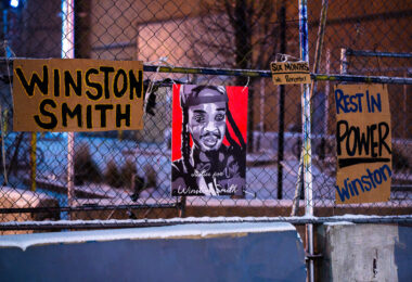 Protest signs hang on fencing outside the Lake & Girard parking ramp. The day prior was 6 months from the day Winston Smith was killed by a Federal Marshal task force.