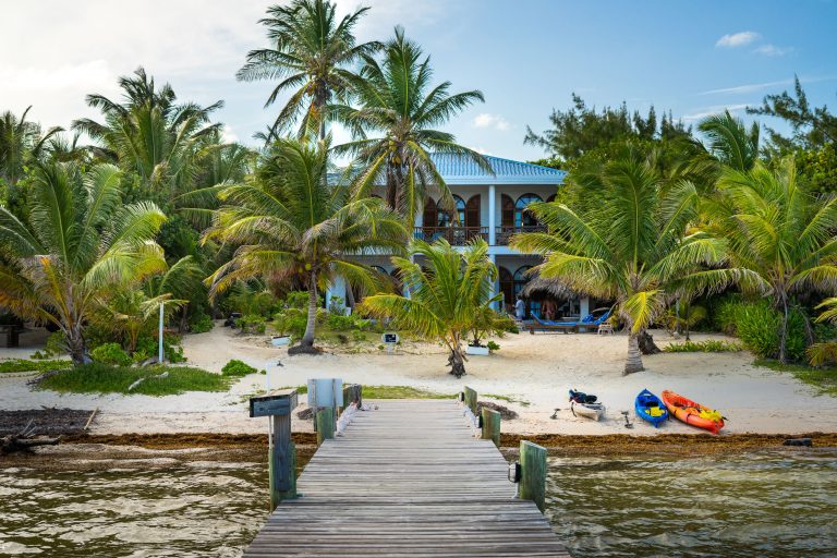 Casa BajaMar Villa, Ambergris Caye, Belize 3 Blue colonial house with palm trees and wooden dock on Ambergris Caye, Belize beach.