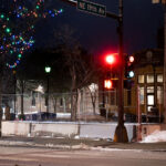 Minneapolis Police Second Precinct Police Station behind security fencing in January 2022 with Christmas lights in the trees.