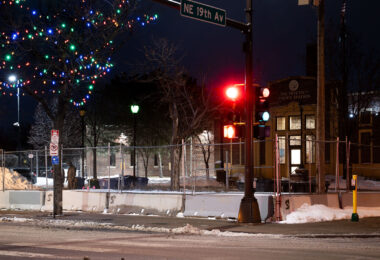 Minneapolis Police Second Precinct Police Station behind security fencing in January 2022 with Christmas lights in the trees.