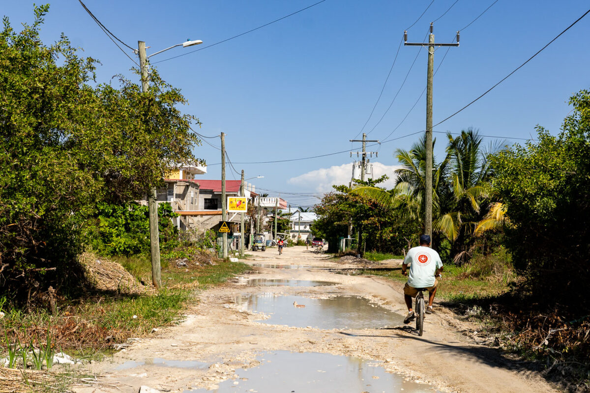 A cyclist rides on a waterlogged, unpaved street in San Pedro, Belize, on Ambergris Caye, where bicycles are a common mode of transport.