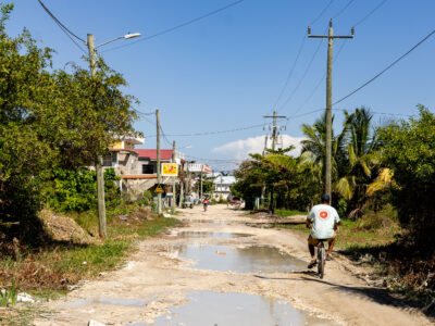 Cyclist on Unpaved Street, San Pedro, Belize