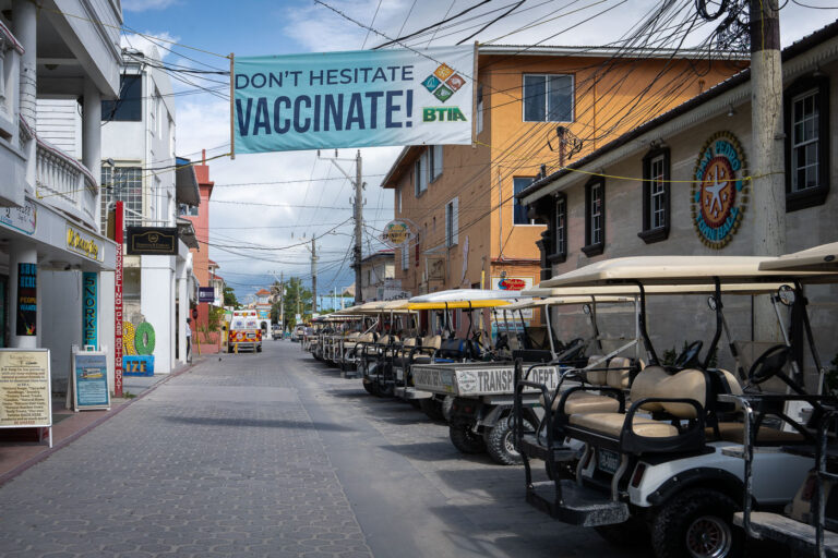San Pedro, Belize: "Don't Hesitate Vaccinate!" Banner 4 A sign reading "Don't Hesitate Vaccinate!" in San Pedro, Belize.