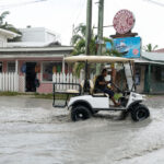 A golf cart is driven in a San Pedro rain storm.