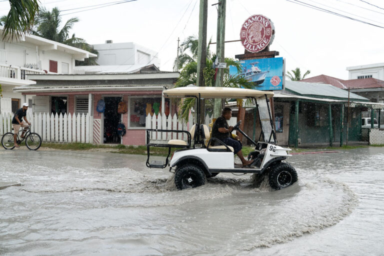 Flooding in San Pedro Belize 3 A golf cart is driven in a San Pedro rain storm.