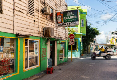 A Belikin beer sign hangs above the entrance to Maha Store in the center of San Pedro on Ambergris Caye. Small neighborhood shops like this one are common throughout the town, serving residents and visitors who travel mostly by golf cart along the island’s narrow streets. The weathered wood siding and bright paint reflect the practical, improvised architecture typical of older commercial buildings in San Pedro, where businesses often blend retail, rentals, and daily essentials in a single storefront.