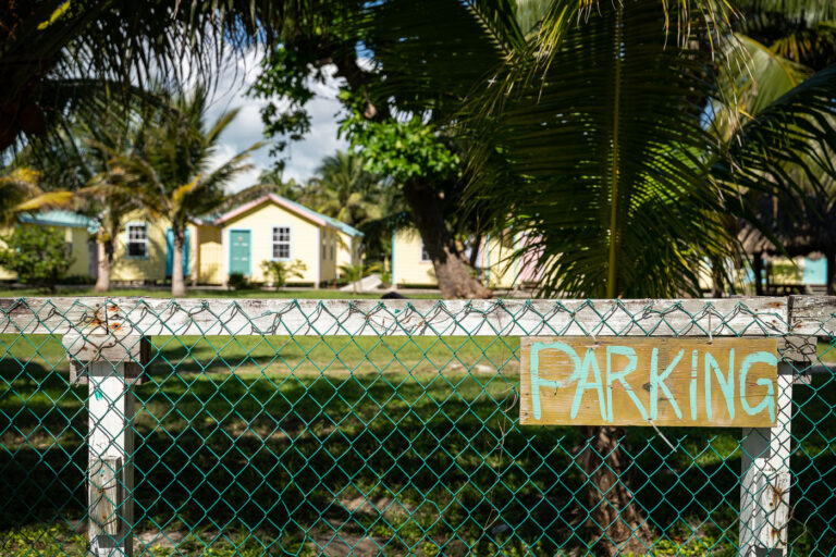 Parking sign in Belize 3 No Parking sign outside the small pastel-colored cottages near the Boca Del Rio area in San Pedro, Belize, serve as guest lodging for visitors to the island. The architecture—simple, elevated wood-frame houses painted in tropical hues—reflects a mix of Creole and colonial influences suited to coastal weather. This district blends tourism accommodations with local residential areas near the island’s northern beaches.