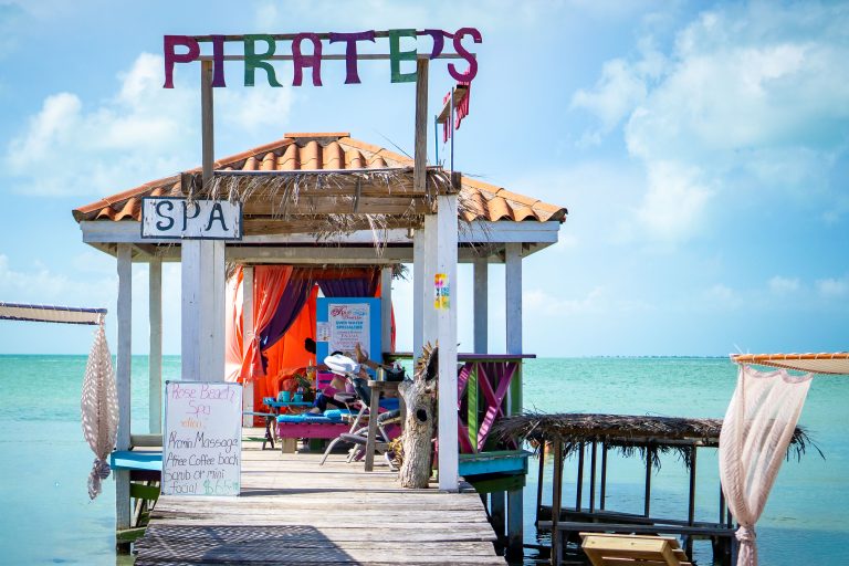 Pirate's Rose Beach Spa, Ambergris Caye, Belize 2 Colorful beachside spa shelter on a wooden pier in Ambergris Caye, Belize, with turquoise water behind.