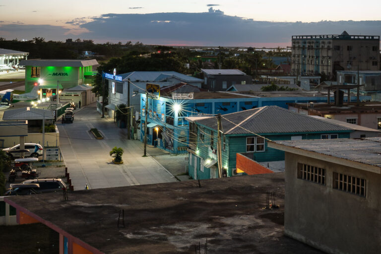 San Pedro, Belize: Dusk at the airstrip and town 2 Dusk settles over San Pedro, Belize, illuminating the town and its airstrip, a vital link for Ambergris Caye. Maya Island Air planes are visible.
