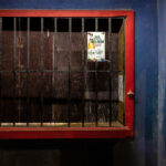A closed storefront in San Pedro, Belize. Written on the wall is “Liquor is not to be consumed on the premises. Liqour will not be sold to anyone under 18 years."