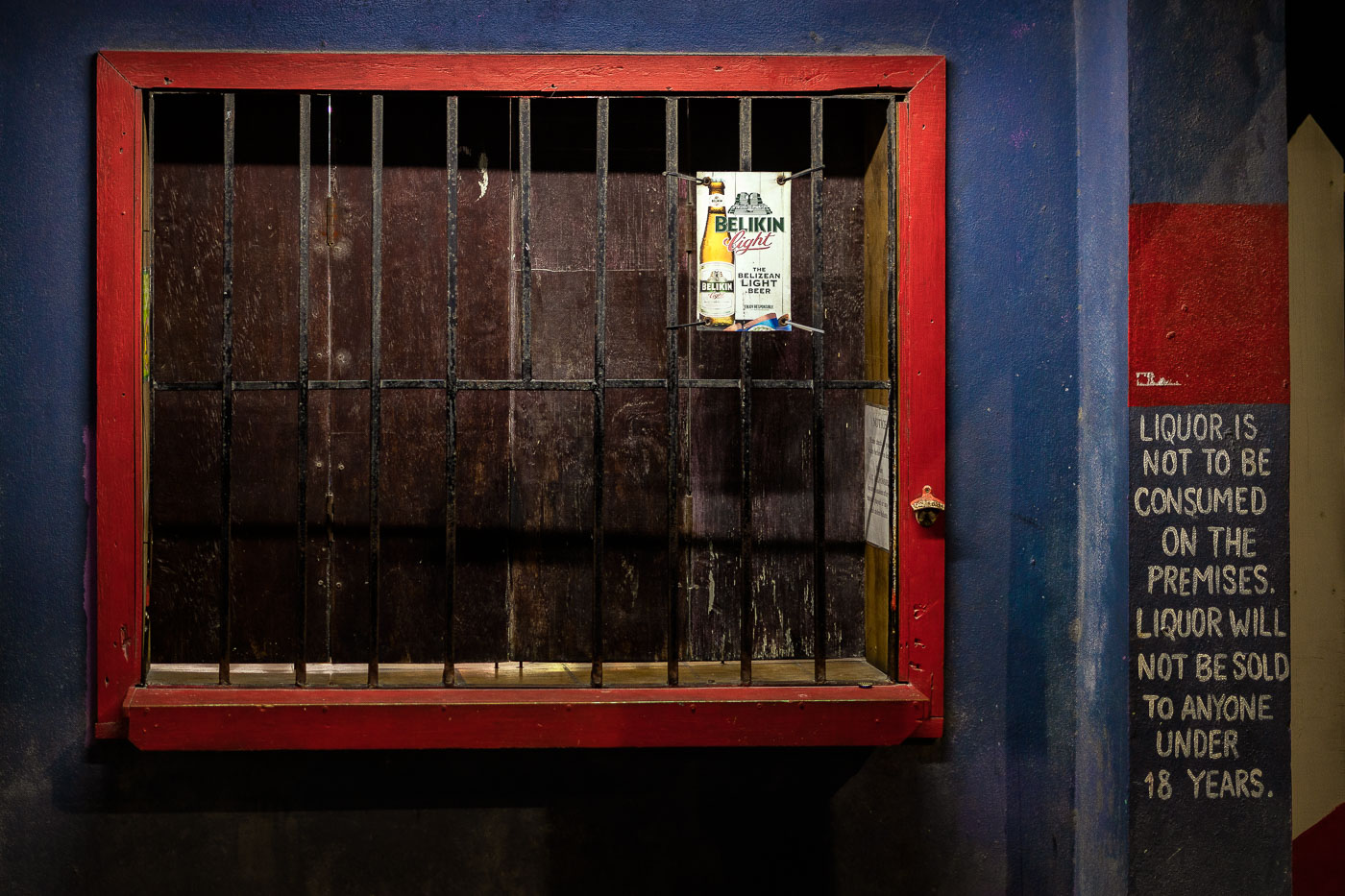 A closed storefront in San Pedro, Belize. Written on the wall is “Liquor is not to be consumed on the premises. Liqour will not be sold to anyone under 18 years."