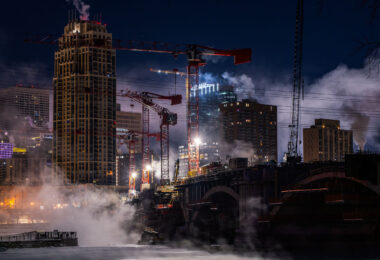 Tower cranes and steam from the Mississippi River on a night where temperatures hit -15F.