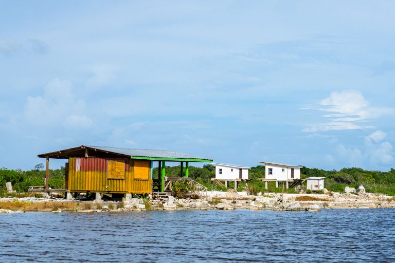 Stilt Fishing Shacks on Ambergris Caye, Belize 1 Colorful shipping container structure and wooden houses on the waterfront of Ambergris Caye, Belize.