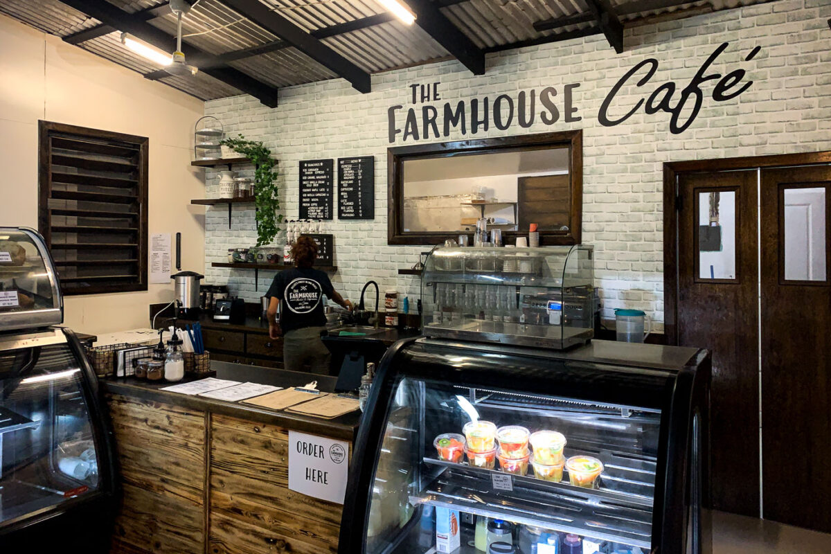 The Farmhouse Cafe interior in San Pedro, Ambergris Caye, Belize, features rustic wood and brick walls, serving as a local gathering spot.