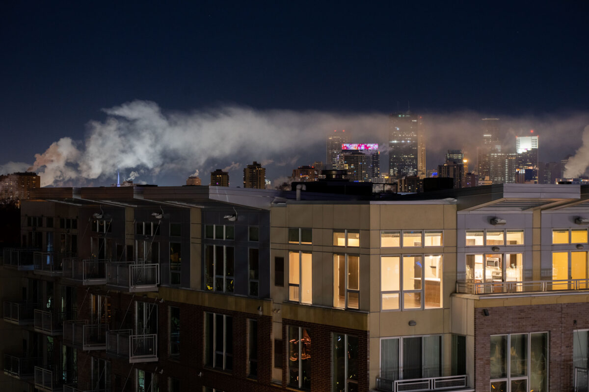 Minneapolis apartment building at night with downtown skyline behind fog