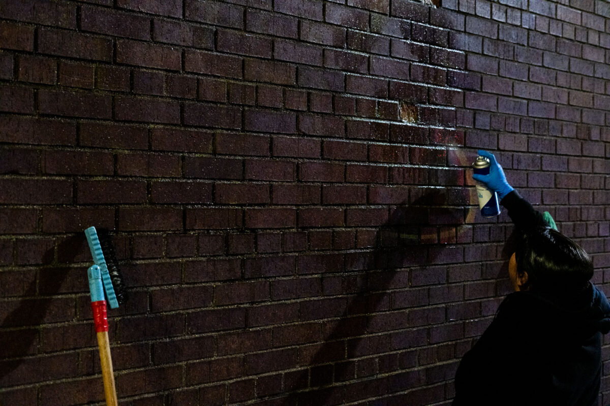 A worker cleans graffiti off the side of a downtown Minneapolis building following a protest over the death of Amir Locke.