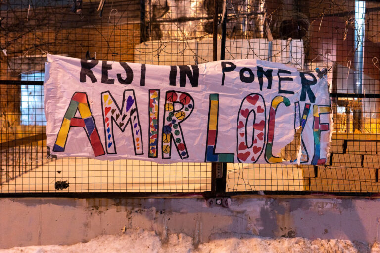 Minneapolis Police 3rd Precinct: Amir Locke Memorial Banner 2 A banner reading "Rest In Power Amir Locke" is displayed on the exterior of the former Minneapolis Police Third Precinct building. The banner was erected following the death of Amir Locke, who was killed by police during a no-knock warrant execution in February 2022. The Third Precinct building was a site of significant protest activity in 2020 after the murder of George Floyd and was subsequently vacated by the Minneapolis Police Department. This memorial serves as a statement against police violence and a remembrance of Locke.