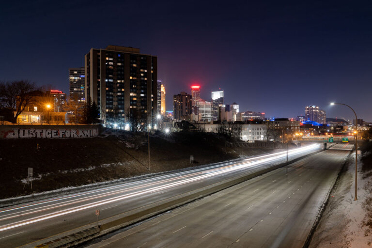 Minneapolis I-94 Graffiti: Justice for Amir Locke 4 Graffiti reading "JUSTICE FOR AMIR" is visible on a hillside overlooking Interstate 94 in Minneapolis. This message appeared following the death of Amir Locke, a young Black man killed by Minneapolis police during a no-knock warrant execution in February 2022. The protest occurred on the same night that activists called for the firing of Minneapolis' interim police chief and an officer involved in the incident. The graffiti serves as a visual marker of ongoing public dissent and demands for accountability in Minneapolis.