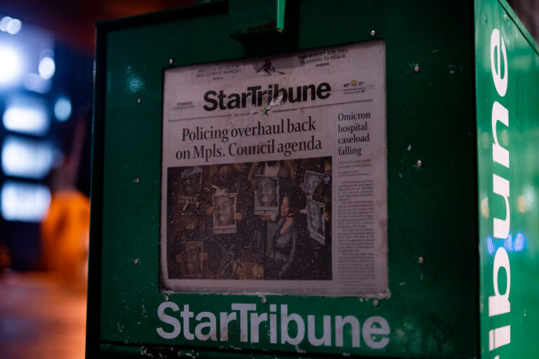 Minneapolis Star Tribune: Policing Overhaul on Council Agenda 1 A newspaper box displays the Minneapolis Star Tribune, dated Tuesday, February 8, 2022, with the headline "Policing overhaul back on Mpls. Council agenda." The front page prominently features images of Amir Locke, who was killed by Minneapolis police during a no-knock warrant execution. The article addresses the city council's agenda concerning policing reforms following Locke's death. The Star Tribune is a major newspaper serving the Minneapolis-Saint Paul metropolitan area and the state of Minnesota.