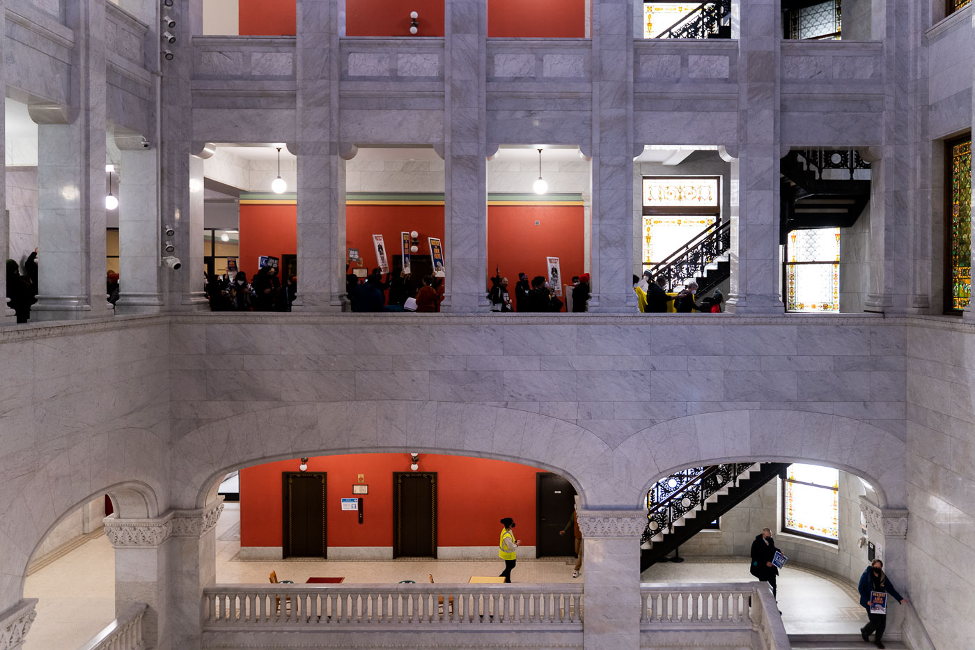 Protesters gathered inside Minneapolis City Hall to deliver ethics complaints against Mayor Jacob Frey, following the police shooting death of Amir Locke on February 2, 2022. Completed in 1909, Minneapolis City Hall serves as the seat of government for the city, housing its administrative offices and City Council chambers. The building's Beaux-Arts architecture is characterized by its grand marble interior and ornate stained-glass windows. This event highlights ongoing public scrutiny and demands for accountability within the city's governmental structure.