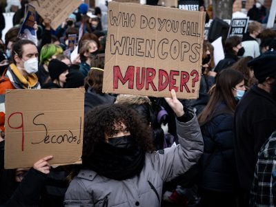 Students hold protest signs after Amir Locke killing