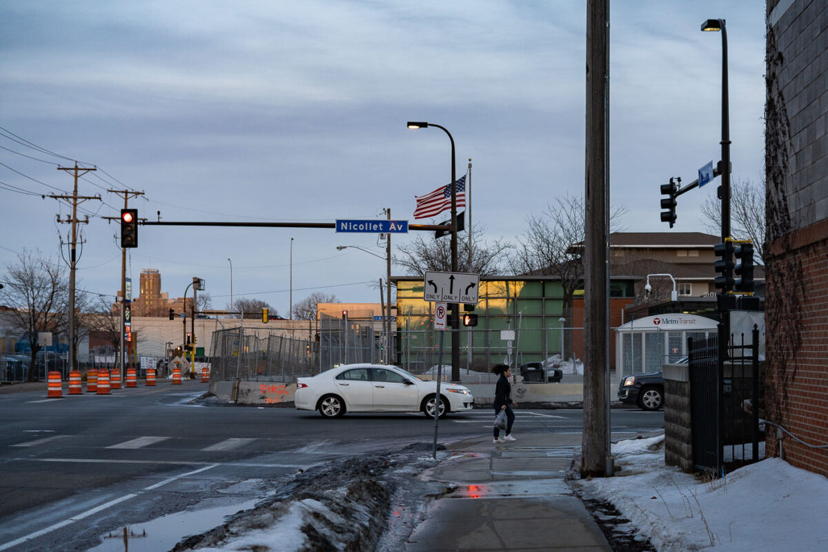 A woman walks in front of the fenced in Minneapolis police fifth precinct.