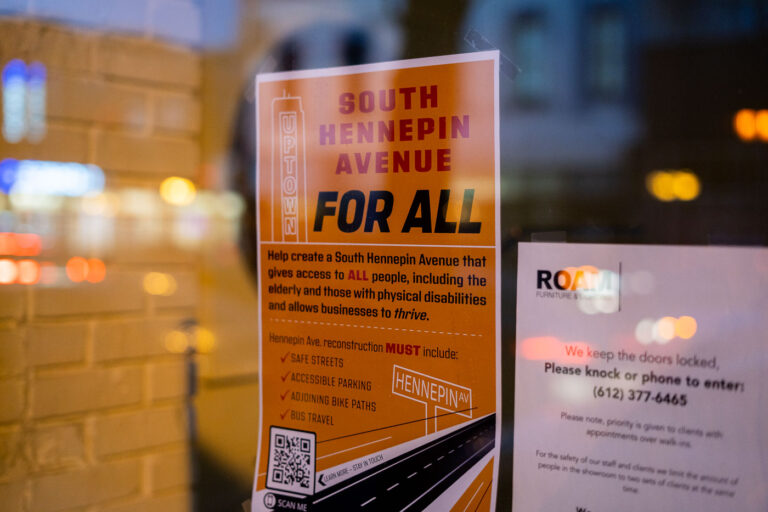 South Hennepin Avenue For All Sign, Uptown Minneapolis 4 A flyer posted in a storefront window in Uptown Minneapolis advocates for a "South Hennepin Avenue For All" initiative. The poster outlines community demands for the street's reconstruction, emphasizing safe streets, accessible parking, bike paths, and bus travel. It calls for the avenue to be designed to accommodate all users, including the elderly and individuals with disabilities, while also supporting local businesses. The "Uptown Minneapolis" branding and the "ROAM" furniture store sign visible in the background indicate the local context of this advocacy during a period of infrastructure planning for Hennepin Avenue.