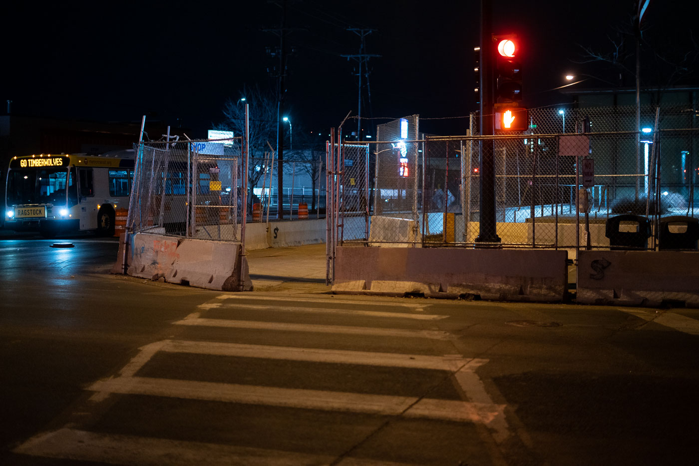 The Minneapolis Police Department's 5th Precinct is shown barricaded at night, surrounded by temporary fencing and concrete barriers. This measure was put in place during periods of civil unrest in Minneapolis, notably following the murder of George Floyd in May 2020. The precinct, located in South Minneapolis, serves as a key law enforcement hub for the area. The presence of barricades highlights the heightened security and the impact of public demonstrations on municipal infrastructure.