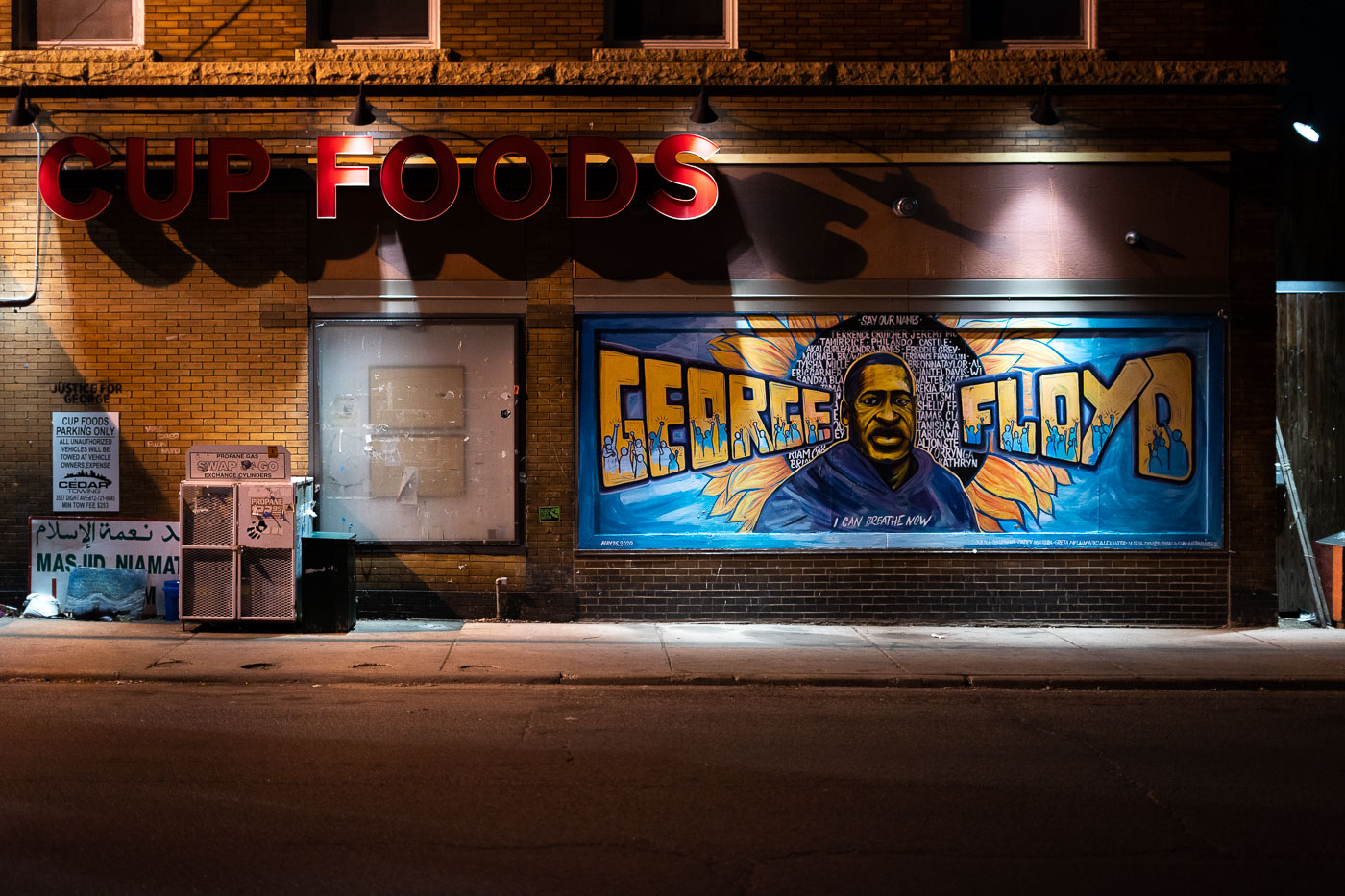 The "George Floyd Mural" is painted on the exterior wall of Cup Foods, a grocery store located in Minneapolis, Minnesota. This mural was created in honor of George Floyd, who died on May 25, 2020, outside this establishment after being subjected to police brutality. The artwork, situated in the area that became known as George Floyd Square, serves as a memorial and a symbol of the protests and uprising that followed Floyd's death. The mural features Floyd's portrait, the phrase "I Can Breathe Now," and a list of other victims of police brutality, functioning as a site of remembrance and a call for justice.