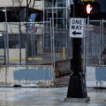 A couple stands behind security fencing surrounding sidewalks and entrances to Seven Points Mall.