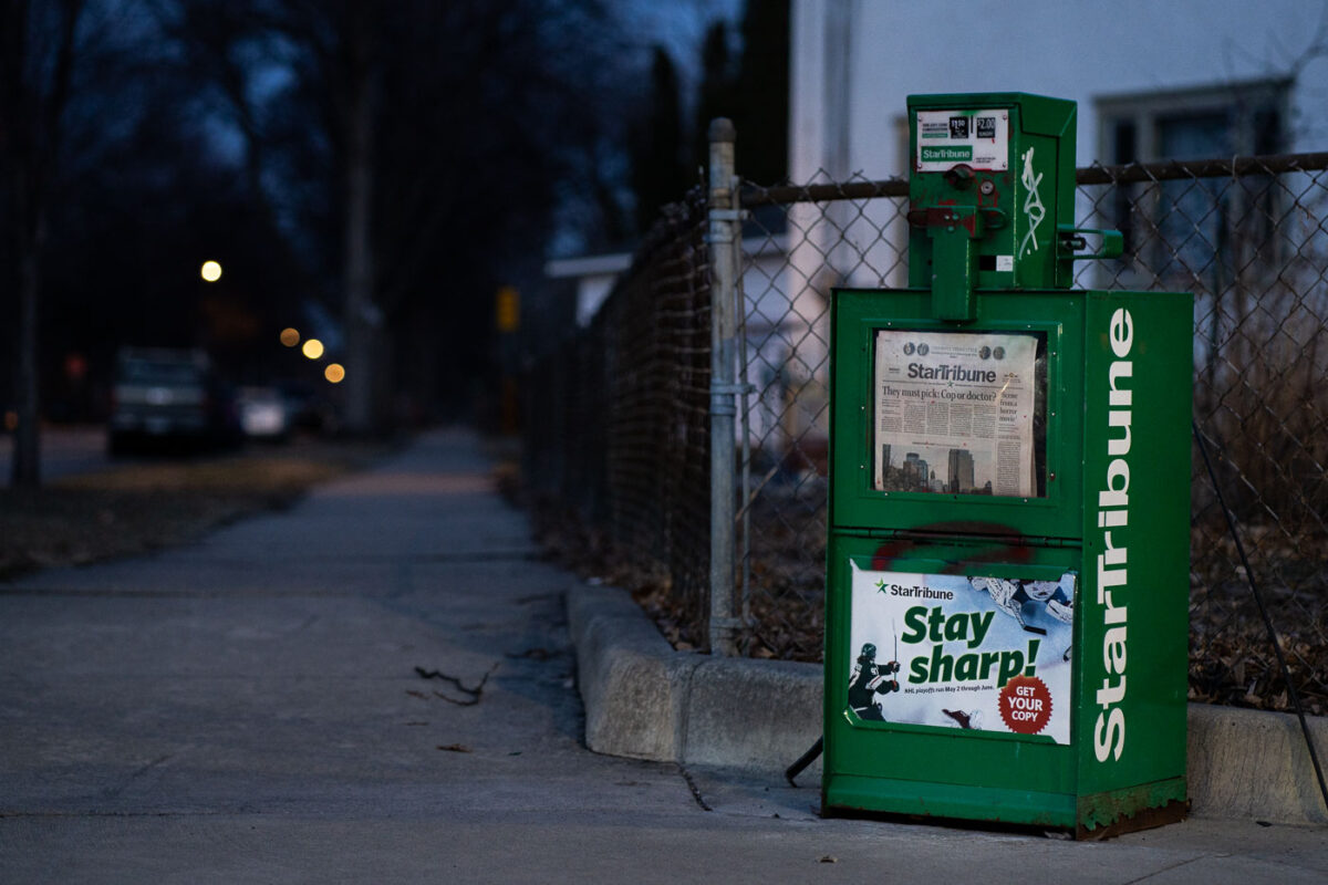 A news rack in South Minneapolis. Star Tribune headline "They must pick: Cop or doctor?"