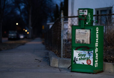 A news rack in South Minneapolis. Star Tribune headline "They must pick: Cop or doctor?"