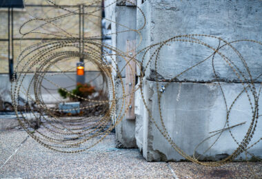 Razor wire around the concrete blocks at the burned Minneapolis 3rd Precinct police station.