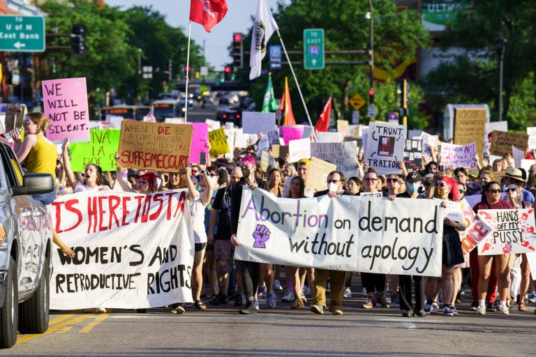 Abortion Rights March After Dobbs Ruling, Minneapolis 2 Protesters march through downtown Minneapolis carrying banners for abortion rights after the 2022 Roe v. Wade ruling.